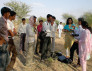 A social scientist sits among ICTD workers
